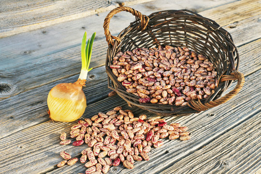 Kidney beans in wicker basket and on wooden table