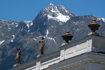Skulpturen auf dem Dach des Kurhauses in Meran vor Bergkulisse, Südtirol, Italien,