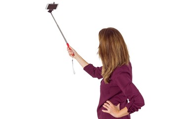 Wear view of pretty woman using a selfie stick