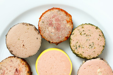 A variety of round pates on plate. From above.