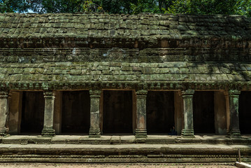 Fototapeta premium frontal sight of a gallery with pillars and false vault in the archaeological ta prohm place in siam reap, cambodia