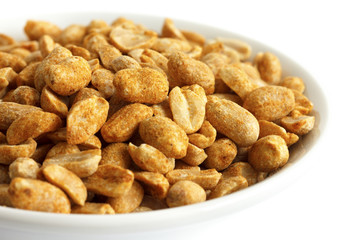 Spicy dry roasted peanuts in white bowl. Isolated.