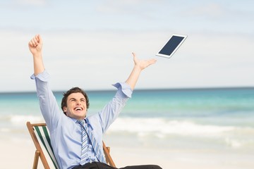 Businessman launching his tablet computer 