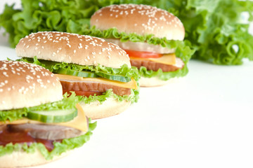 three burger with meat and vegetables