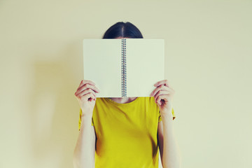 young woman holding open notebook