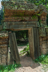 door in ruins in the wall of laterite that surrounds the archaeological ta prohm place in siam reap, cambodia