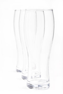 three empty beer glasses in vertical white background