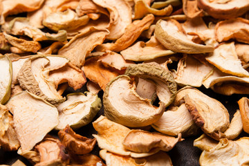 slices of dried apples as background on black