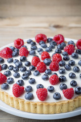 Cake with blueberries and raspberries. Confectionery product.