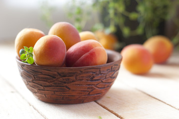 apricots in ceramic cup on wooden table. selective focus