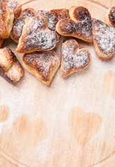 bakery hearts from split pastry with sugar powder on wooden