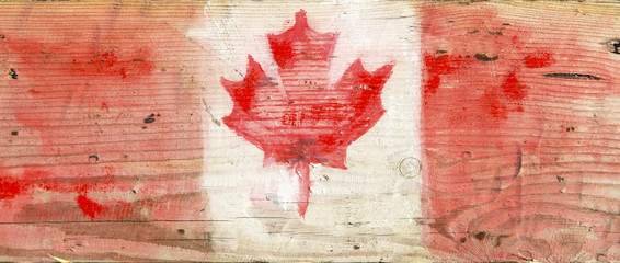 Canadian flag on wood Unusual painting of Canadian national flag with Maple leaf symbol on warm natural wood background