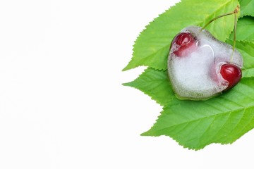 Cuore di ghiaccio con ciliegie su foglie di ciliegio 
