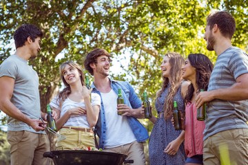 Happy friends in the park having barbecue