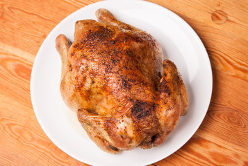 roast chicken on white plate and wooden