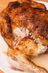 roast chicken on white plate and wooden