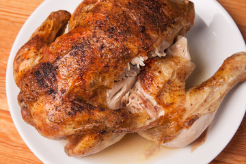 roast chicken on white plate and wooden