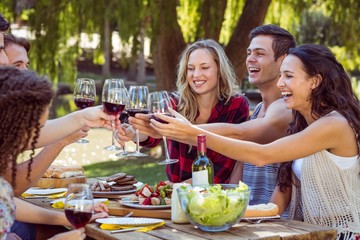 Happy friends in the park having lunch