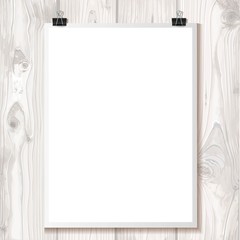 White paper hanging on binder on a background texture of light wood