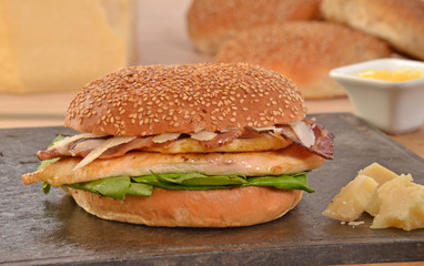 Hamburguesa de pollo e ingredientes sobre plancha caliente.