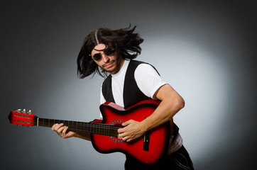 Man wearing sunglasses and playing guitar