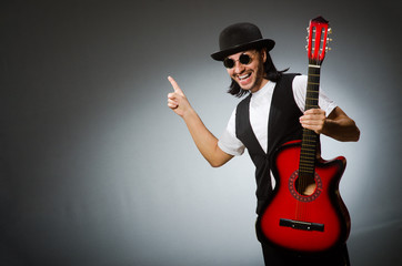 Man wearing sunglasses and playing guitar