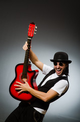 Fototapeta premium Man wearing sunglasses and playing guitar
