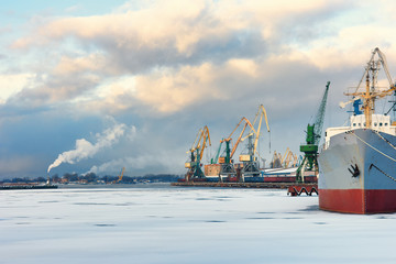 Ship and cranes in the port of winter