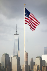 the flag of the United States in front of the skyscrapers in New York