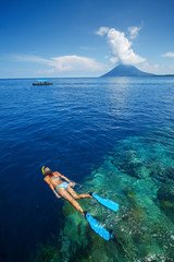 Lady snorkeling over reef wall