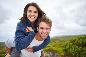 Fototapeta premium Young couple smiling confidently while outdoors together