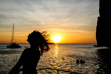 Silhouette einer Frau im Sonnenuntergang vor Trauminsel