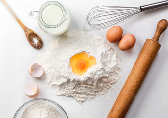 baking background with raw eggs, sugar, flour , milk and butter
