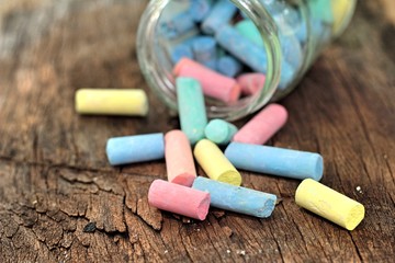 Colorful chalk placed on old wood background