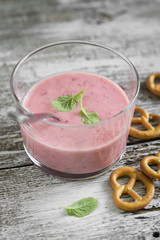 cold strawberry soup in a glass beaker on a light wooden background