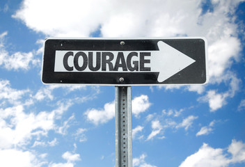 Courage direction sign with sky background