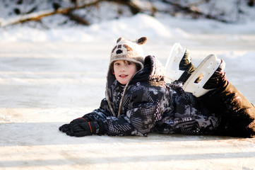 young boy on a frozen pond wearing ice skates