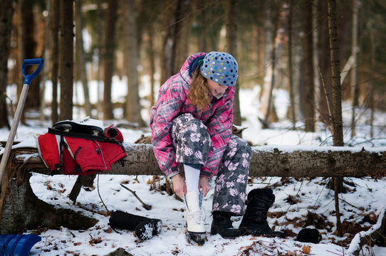 Girl Putting On Ice Skates To Skate On A Pond