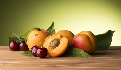 apricots and cherries on the wooden table