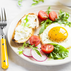 fried egg, vegetable salad and a grilled cheese sandwich on a light background
