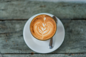 Cup of latte coffee on old wooden table
