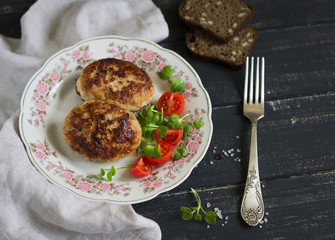 pork cutlet and vegetable salad on a dark wooden background