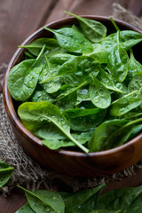 Close-up of spinach leaves in a wooden bowl, selective focus