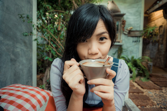 Asian beautiful cute girl in the cafe garden with coffee smiling