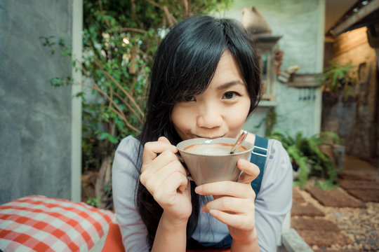 Beautiful resting asian woman with cup of coffee