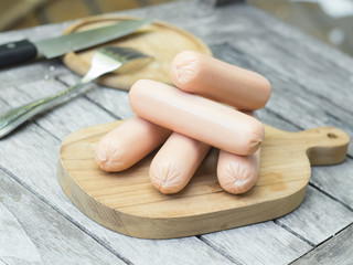 Sausages on wooden chopping board