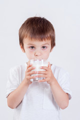 Cute little boy, drinking milk, holding glass of milk, mustaches