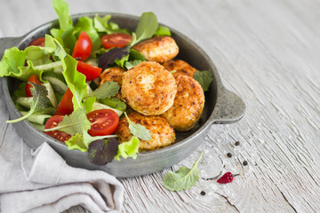chicken cutlets and fresh vegetable salad in a vintage pan 