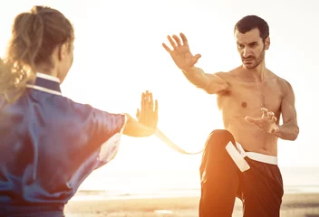 Abwaschbare Fototapete Kampfkunst Paar trainiert Kampfkunst am Strand
