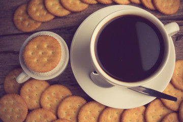 Cup of coffee on a wooden board and biscuits